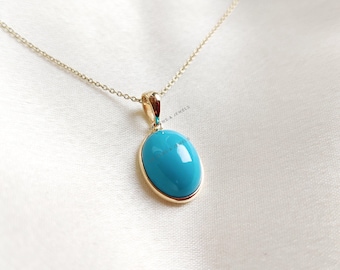 Puede incluir: Un collar de cadena de oro con un colgante ovalado turquesa.