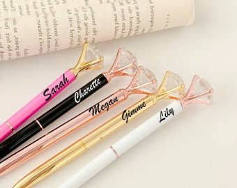 May include: Five pens with diamond-shaped tops and personalized names: Sarah, Charette, Megan, Gimme, and Lily. The pens are in various colors, including pink, black, gold, and white.