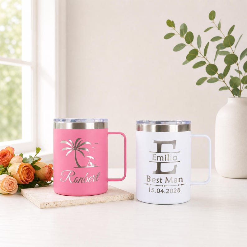 May include: Two stainless steel travel mugs with silver accents. One is pink with a beach scene and the name "Ronbert". The other is white with the name "Emilio", "Best Man", and the date "15.04.2026". Both have handles and lids.