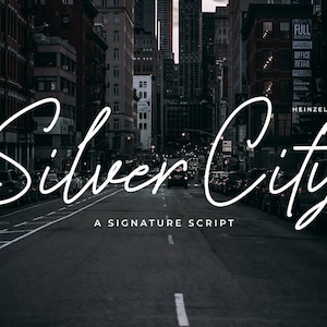 May include: A black and white image of a city street at night with the text "Silver City" in a white cursive font. The text is below the words "A Signature Script" in a smaller font.