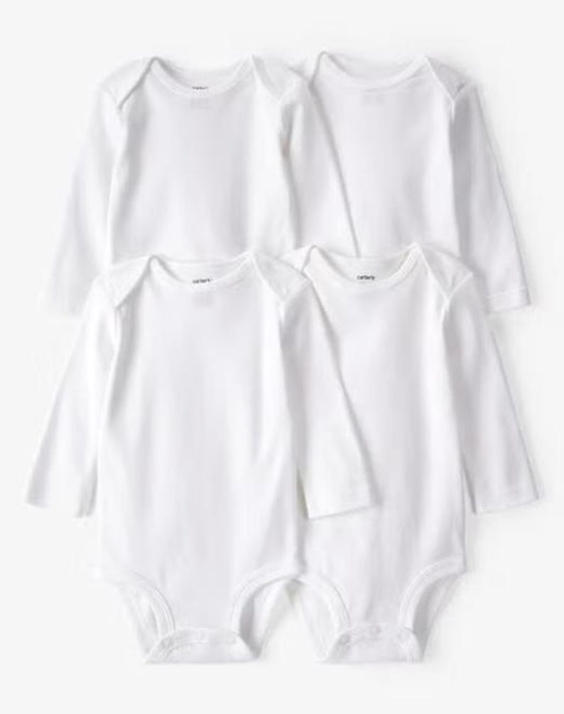May include: Four white long-sleeved baby bodysuits. Each bodysuit features a round neckline and a snap closure at the bottom. The Carter's brand logo is visible on the neckline. The bodysuits are made of a soft, comfortable material.