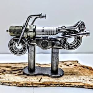 Op de afbeelding: Een handgemaakt houten bord met de tekst "Welcome" in een speels lettertype. Het bord is wit geschilderd met een verweerde afwerking en heeft een decoratief bloemmotief in roze en groene tinten. Het is ongeveer 30 cm breed.