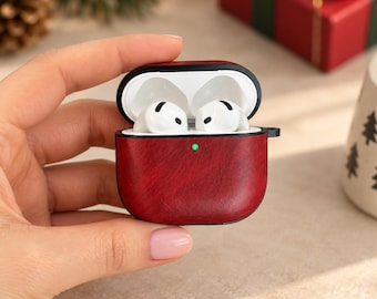 May include: A dark red, wood-grain textured protective case for wireless earbuds. The case is open, revealing two white earbuds inside. A small, circular green LED light is visible on the front of the case, indicating a charge status.