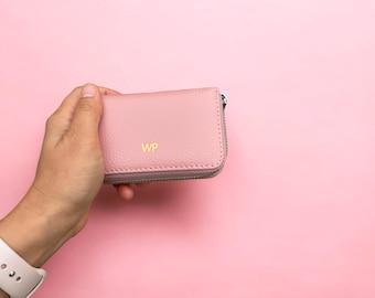 May include: A pink leather zipped wallet with the initials "WP" embossed in gold.