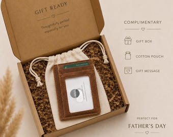 May include: A brown leather card holder with a clear ID window, placed inside a beige cotton drawstring pouch within a brown cardboard gift box. The box lid interior reads GIFT READY, and the side lists COMPLIMENTARY GIFT BOX, COTTON POUCH, GIFT MESSAGE.