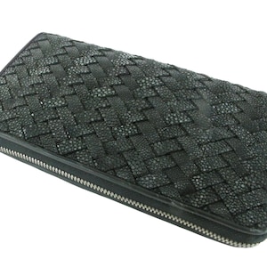May include: A rectangular black wallet featuring a woven texture pattern across the surface. The wallet is constructed with a textured material that has a granular appearance and is secured by a silver-toned metal zip along the outer edge.