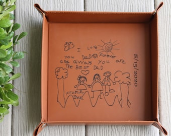 May include: A brown leather tray with a drawing of a family and a sun. The drawing says "I love Dad Forever and always you are the best Dad" and is signed "From Inaxa" and dated "8/15/2020".