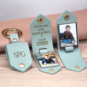 K&ouml;nnte beinhalten: Drei personalisierte Schl&uuml;sselanh&auml;nger aus Leder in Hellt&uuml;rkis. Ein Schl&uuml;sselanh&auml;nger hat die Initialen "SPG" gepr&auml;gt. Die anderen beiden Schl&uuml;sselanh&auml;nger haben ein Foto und den Text "We love you to the MOON & BACK" mit Namen.