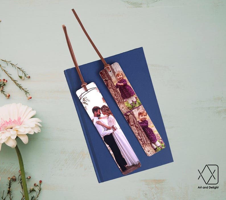 May include: Two personalized bookmarks with photos printed on them. One bookmark features a couple in a forest setting, while the other bookmark features a young girl in a purple dress in a forest setting.