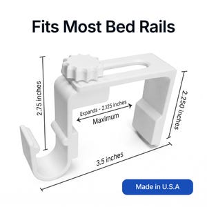 Op de afbeelding: Witte bedrailsbeugel met afmetingen in inches. Het zet uit tot 5,4 cm, is 7 cm hoog en 8,9 cm lang. De tekst "Fits Most Bed Rails" staat bovenaan en "Made in U.S.A" onderaan.