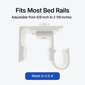 Op de afbeelding: Een witte verstelbare bedrailsbeugel. De beugel is verstelbaar van 1,6 cm tot 5,4 cm en is voorzien van het label "Made in U.S.A."