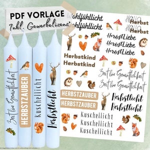 May include: Four blue candles with autumn-themed designs. The candles have labels that say "Zeit für Gemütlichkeit", "Herbstzauber", "Kuschellicht", and "Herbstlicht". The image also includes a sheet of stickers with various autumn-themed designs, including animals, leaves, and hearts.