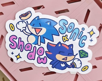 May include: A white sticker with a blue and red cartoon Sonic the Hedgehog and a black and red cartoon Shadow the Hedgehog. The sticker says "Sonic & Shadow" in pink and blue letters.