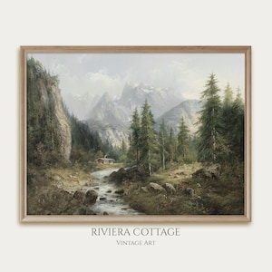 May include: A vintage painting of a mountain landscape with a small cabin by a river. The painting is framed in a light wood frame. The text "RIVIERA COTTAGE" and "VINTAGE ART" is printed below the frame.