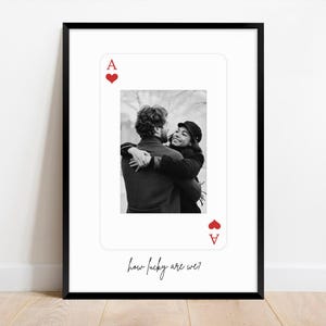 May include: Framed print with a black border, displaying a black and white photograph of a couple hugging, framed as an Ace of Hearts playing card. Red heart symbols mark the suit. The text "how lucky are we?" is written below in cursive.