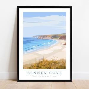 May include: Framed art print of Sennen Cove, Cornwall. The artwork shows a coastal scene with a sandy beach, blue ocean, and cliffs under a blue sky. The print includes the text "Sennen Cove Cornwall" at the bottom.