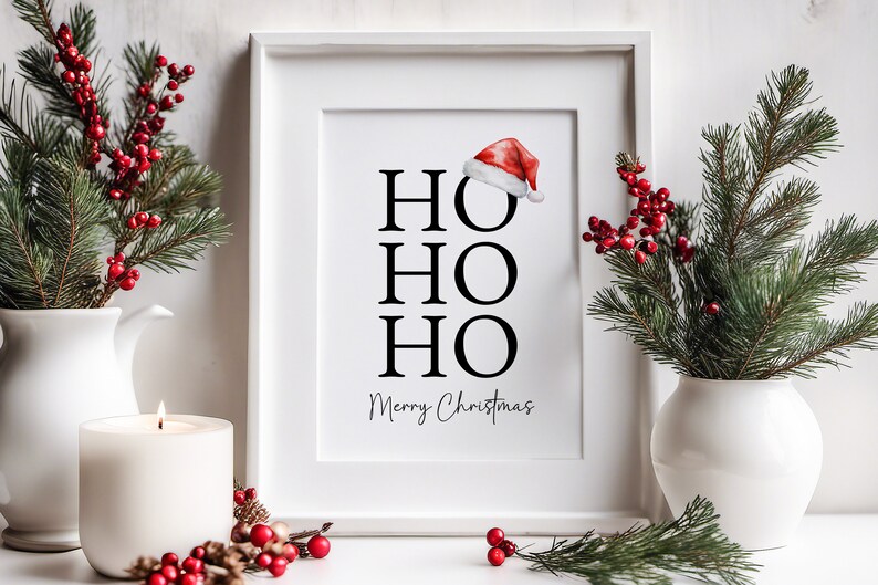 May include: White framed print with the text "HO HO HO Merry Christmas" in black lettering. A red Santa hat is above the text.