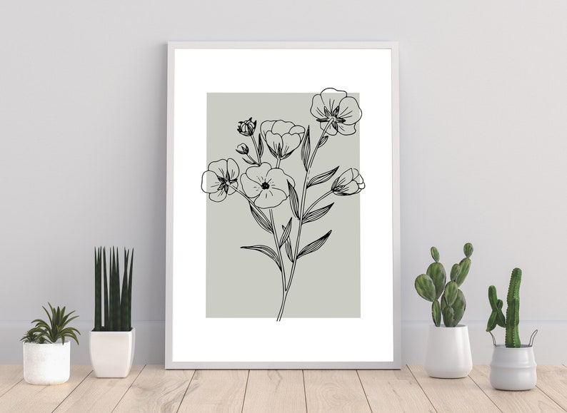 Pode incluir: Um desenho a preto e branco de flores sobre um fundo verde claro. O desenho est&aacute; emoldurado numa moldura branca e &eacute; apresentado numa parede branca.