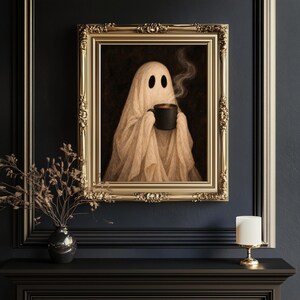 May include: A framed wall art print featuring a beige ghost figure draped in fabric, holding a black mug with rising steam. The artwork is encased in an ornate, metallic gold rectangular frame with intricate carved detailing on the edges.