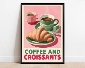 May include: A framed art print featuring a pink background with two cups of coffee and a croissant on a plate. The text "COFFEE AND CROISSANTS" is displayed in green and red. The coffee cups are green and pink.