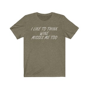May include: A green t-shirt with the text "I like to think wine misses me too" printed in white.