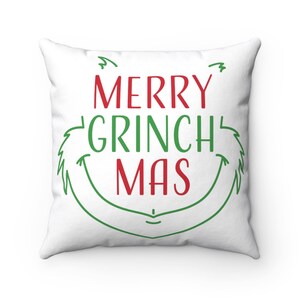 May include: White throw pillow with green and red text that reads "Merry Grinch Mas" with a green Grinch-like face around the text.