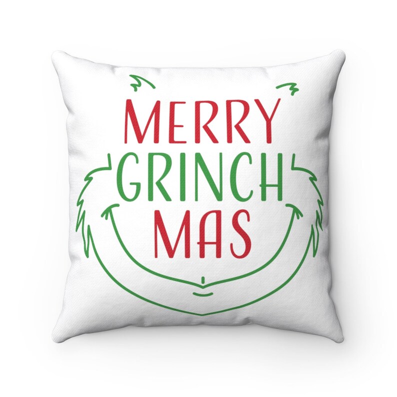 May include: White throw pillow with green and red text that reads "Merry Grinch Mas" with a green Grinch-like face around the text.