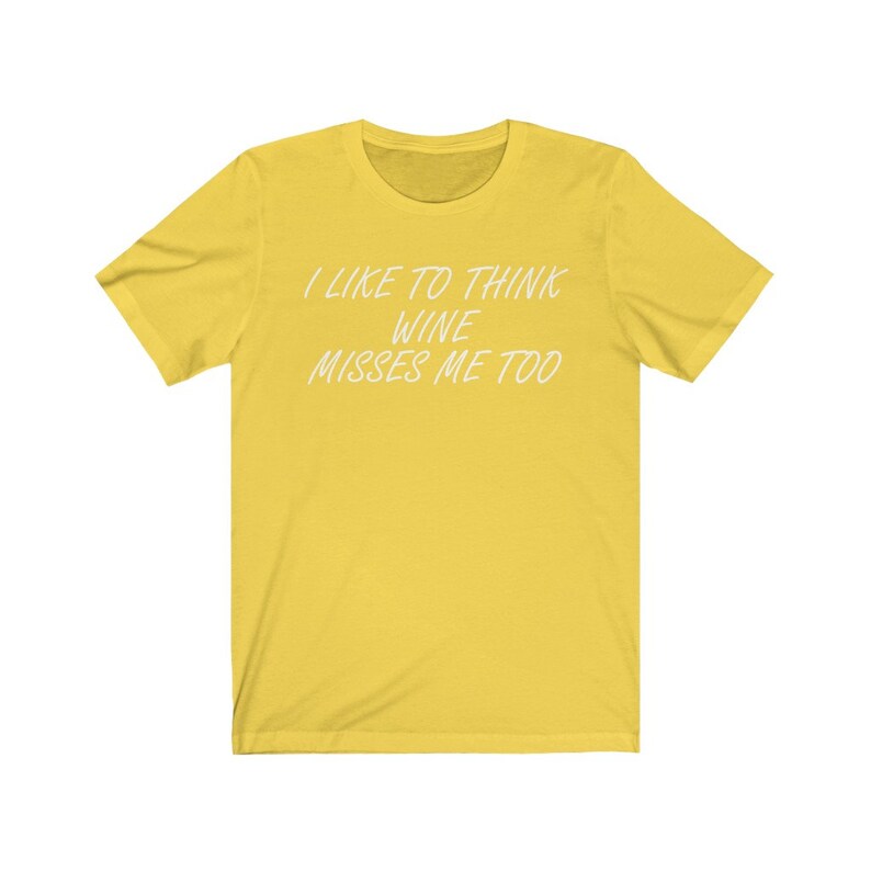 May include: Yellow short-sleeved t-shirt with the text "I like to think wine misses me too" in white.