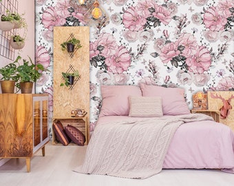 May include: A bedroom with a pink floral wallpaper, a bed with a pink blanket and pillows, a wooden dresser with plants, and a wooden side table with a deer head sculpture.