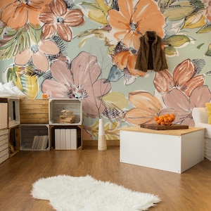 May include: A living room with a white couch, a white coffee table, and a floral wallpaper. The wallpaper features large, colorful flowers in shades of pink, orange, and yellow. The room is decorated with wooden crates and a white rug.