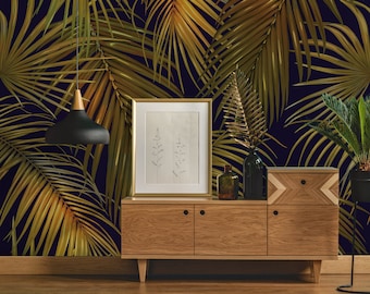 Könnte beinhalten: Ein Holzschränkchen mit drei Schubladen und zwei Türen, mit einem goldgerahmten Bild und einer schwarzen Lampe, die darüber hängt. Der Schrank steht vor einer dunkelblauen Wand mit einem goldenen Palmenblatt-Muster.