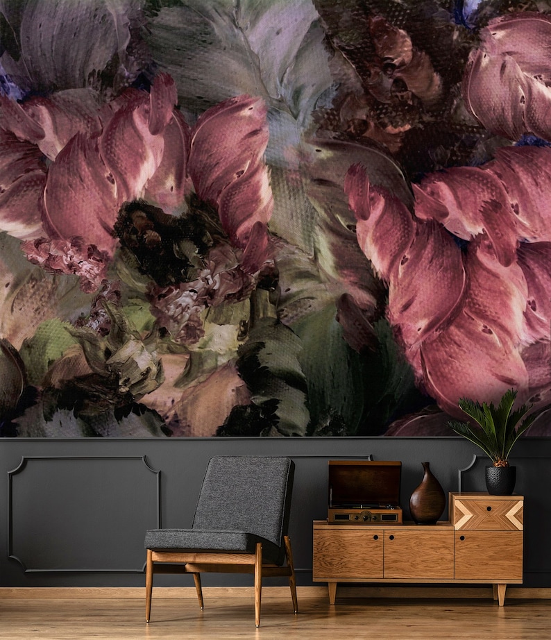 May include: Abstract floral painting in shades of pink, green, and brown. The painting is displayed above a dark gray wall with a wooden cabinet and a gray armchair in front of it.