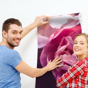 以下が含まれることがあります： 2 人の人が、大きなピンクの花柄の壁紙を貼っています。壁紙は、ピンクの牡丹の花のクローズアップが特徴です。