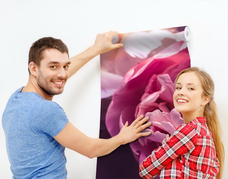 以下が含まれることがあります： 2 人の人が、大きなピンクの花柄の壁紙を貼っています。壁紙は、ピンクの牡丹の花のクローズアップが特徴です。