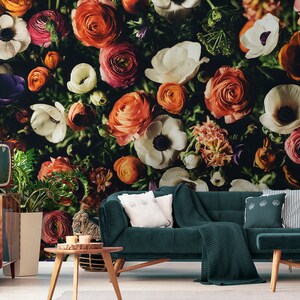 May include: A close-up of a floral wallpaper featuring a variety of colorful flowers, including white anemones, orange ranunculus, and pink roses. The flowers are arranged in a dense cluster, creating a vibrant and textured pattern.