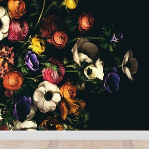 May include: A bouquet of colourful flowers, including white anemones, pink ranunculus, and orange roses, arranged against a black background.