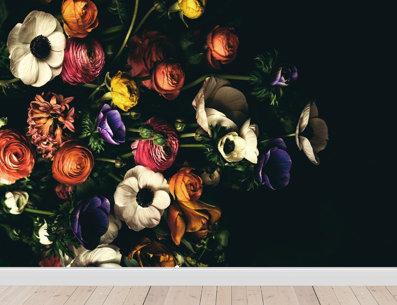 May include: A bouquet of colourful flowers, including white anemones, pink ranunculus, and orange roses, arranged against a black background.