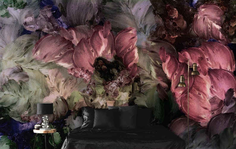 May include: A bedroom interior with a bed, two bedside lamps, and a side table. The wall is covered in a floral wallpaper with a painterly design in shades of purple, pink, and green.