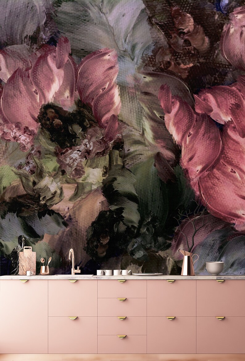 May include: A pink kitchen cabinet with gold handles. The cabinet is in front of a wall with a large abstract floral painting in shades of pink, green, and brown.