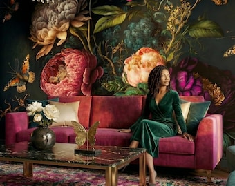 May include: A deep magenta velvet sofa featuring a dark floral wallpaper backdrop with large peonies and butterflies. A marble coffee table with a gold butterfly ornament and a vase of white flowers sits in front of the sofa.
