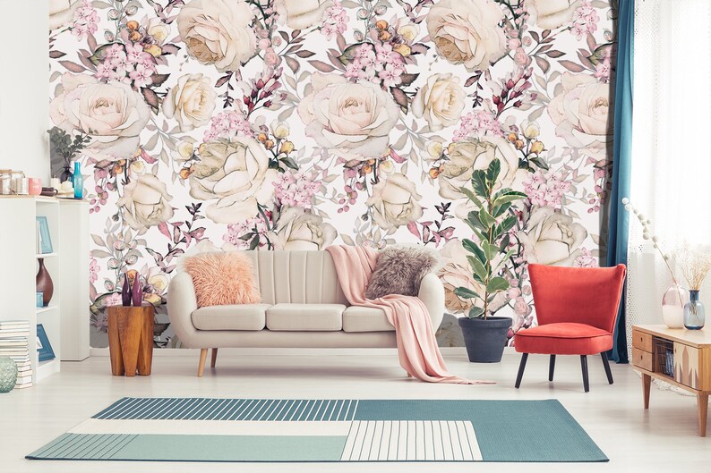 K&ouml;nnte beinhalten: Ein Wohnzimmer-Interieur mit einem wei&szlig;en Sofa und einem roten Sessel. Die Wand ist mit einer floralen Tapete bedeckt, die ein Muster aus rosa und wei&szlig;en Rosen und gr&uuml;nen Bl&auml;ttern zeigt.