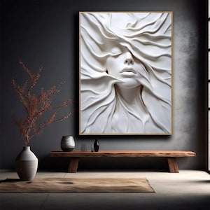 Puede incluir: Una escultura 3D blanca de la cara de una mujer con el pelo fluyendo a su alrededor. La escultura está colocada sobre un fondo gris oscuro.