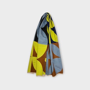 May include: A blue, brown and yellow geometric patterned scarf. The scarf is folded and draped over a white background.