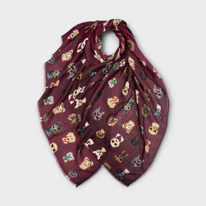Puede incluir: Bufanda burdeos con un estampado repetido de perros con accesorios. Los perros están representados con gafas de sol y pajaritas. La bufanda está hecha de una tela ligera, adecuada para todas las estaciones. Mide aproximadamente 180 cm de largo.