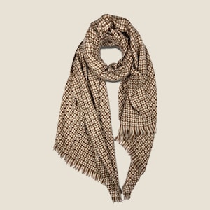 May include: A brown and white geometric patterned scarf with fringed edges.