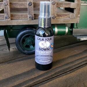 K&ouml;nnte beinhalten: Eine schwarze Spr&uuml;hflasche mit einem wei&szlig;en Etikett, auf dem "Calm Your Down It's a Guy Thing!! Chillin' Out Spray" und "G Sky Lavender Farms Florence Montana" steht.