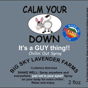 K&ouml;nnte beinhalten: Ein blaues und wei&szlig;es Etikett mit einem Comic-Esel und dem Text "Calm Your Down It's a GUY thing!! Chillin' Out Spray Big Sky Lavender Farms Florence Montana 2 fl oz" Das Etikett ist f&uuml;r eine 59 ml Flasche Lavendelspray.