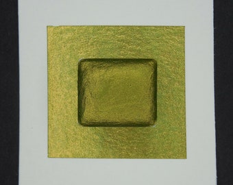 May include: A square of gold watercolor paint in a white frame. The paint is a deep, rich green color with a metallic sheen.