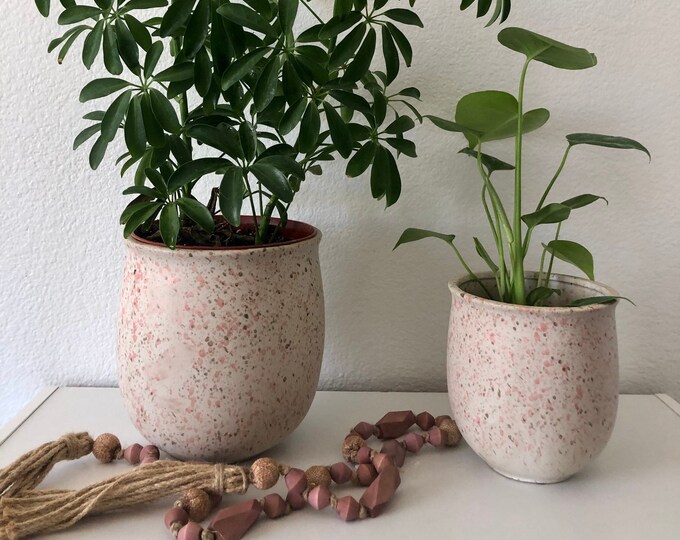 Beige ceramic planter with blush tones paint splatter. Comes in 2 sizes 7"Hx6"D 5 1/2" H x 5" D