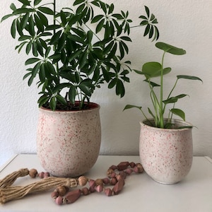Beige ceramic planter with blush tones paint splatter. Comes in 2 sizes 7&quot;Hx6&quot;D 5 1/2&quot; H x 5&quot; D